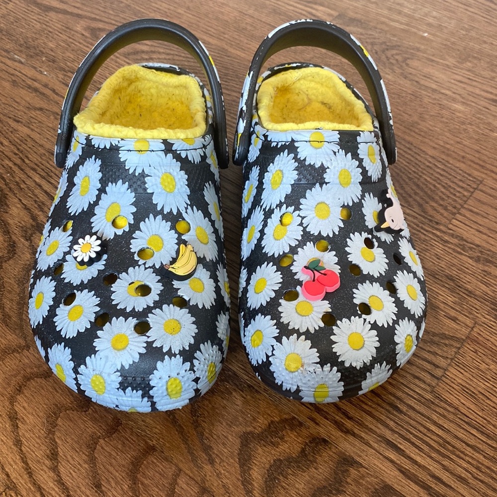 Daisy crocs lined with decorations.